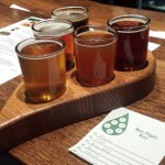 A flight of beers on a bar